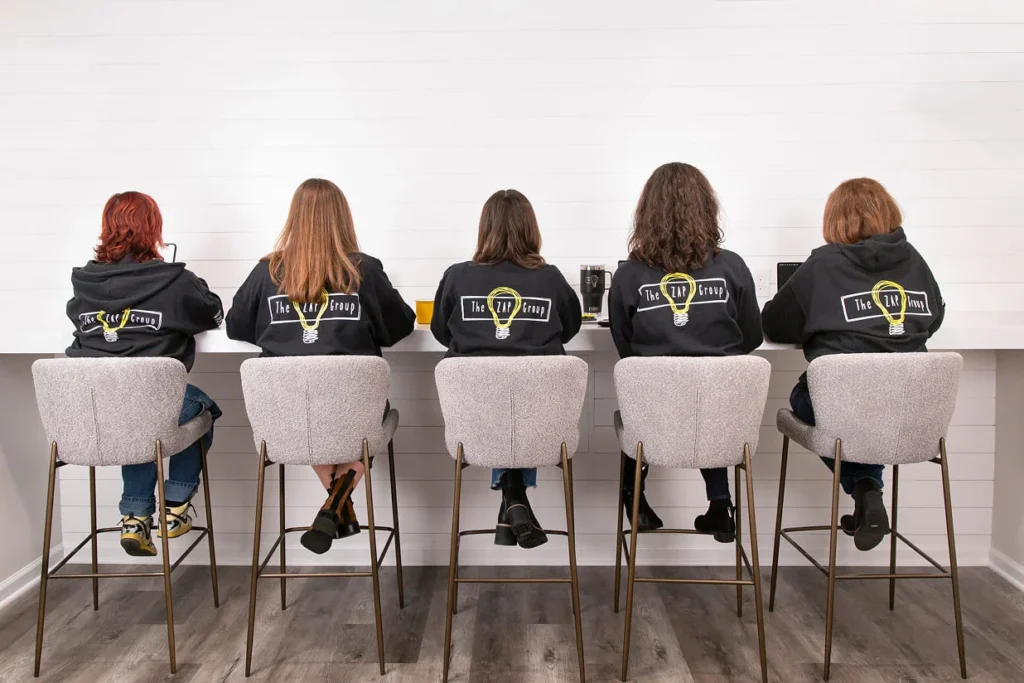 The ZAP Group team in branded hoodies, back view